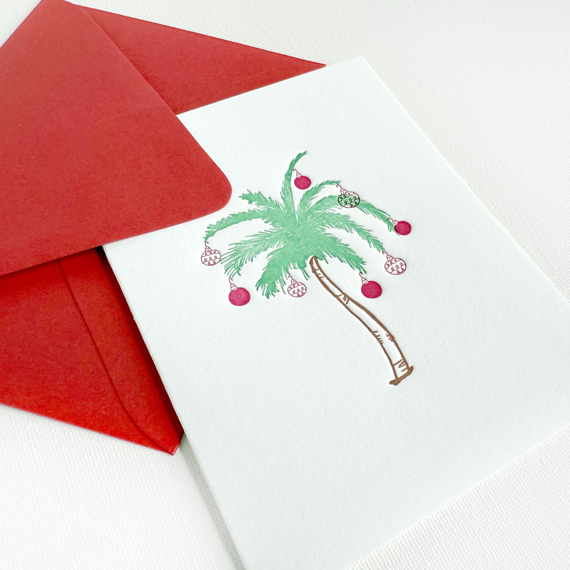 christmas palm tree card
letterpress christmas card
christmas ornaments on a palm tree letterpress greeting card with a red envelope