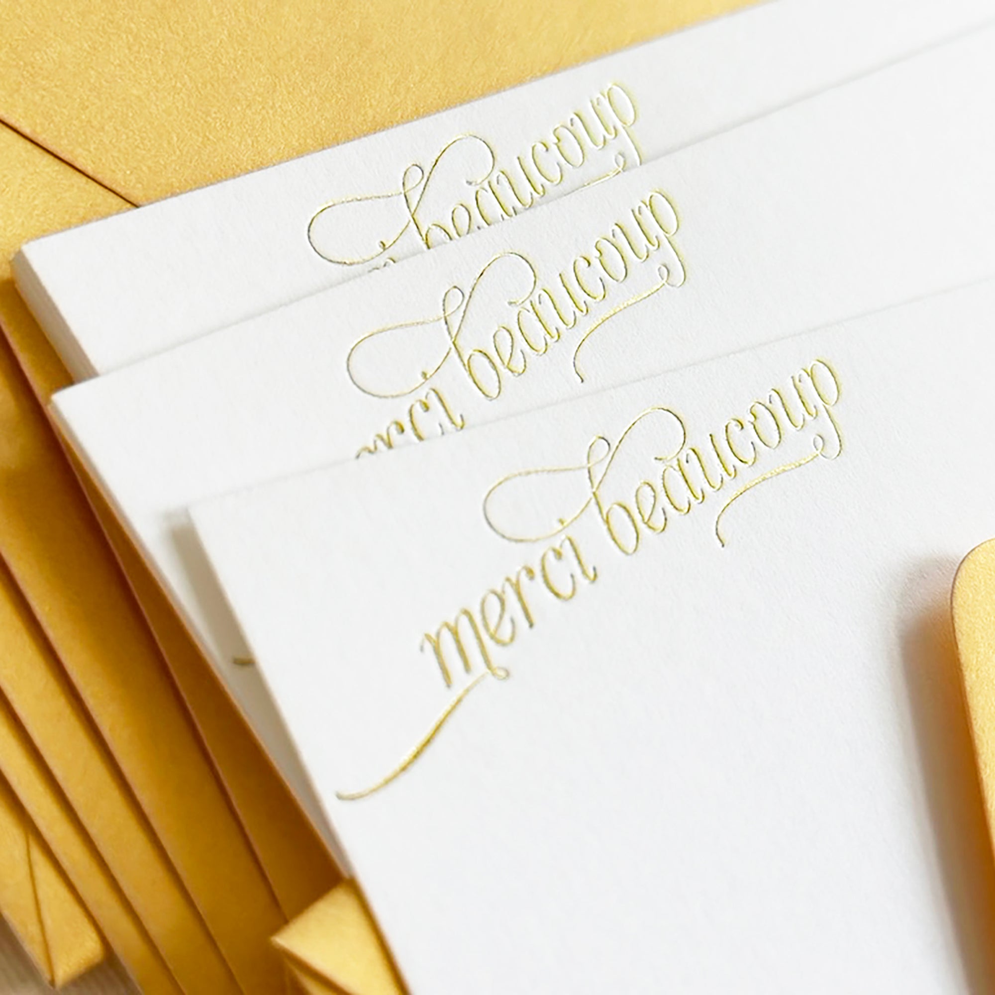 White cards with gold cursive text 'merci beaucoup' in gold foil

gold foil merci beaucoup script boxed set of stationery

gold foil merci beaucoup script boxed set of note cards