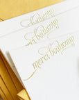 White cards with gold cursive text 'merci beaucoup' in gold foil

gold foil merci beaucoup script boxed set of stationery

gold foil merci beaucoup script boxed set of note cards