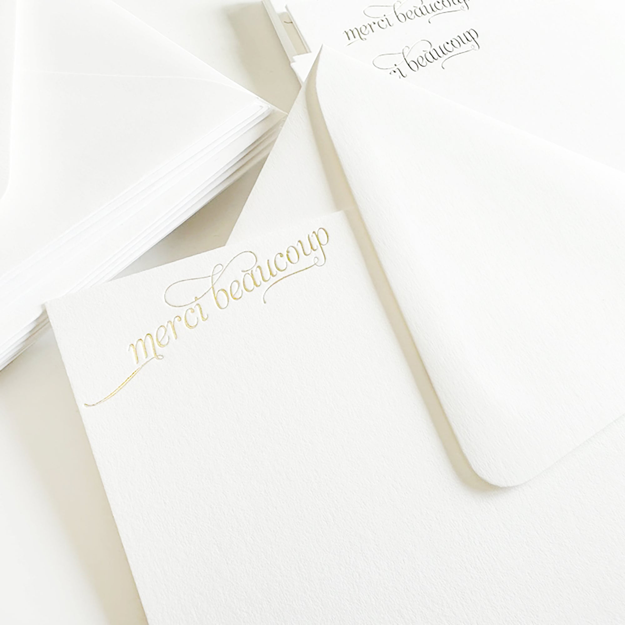White cards with gold cursive text 'merci beaucoup' in gold foil

gold foil merci beaucoup script boxed set of stationery

gold foil merci beaucoup script boxed set of note cards