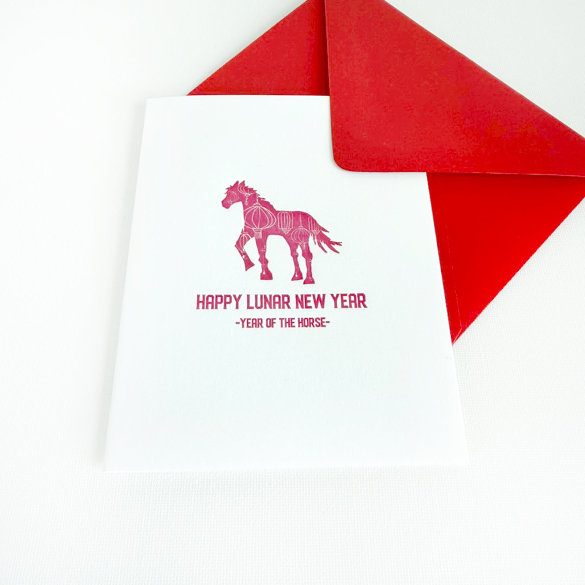 Card with horse illustration and 'Happy Lunar New Year' text on a white background with red envelope.