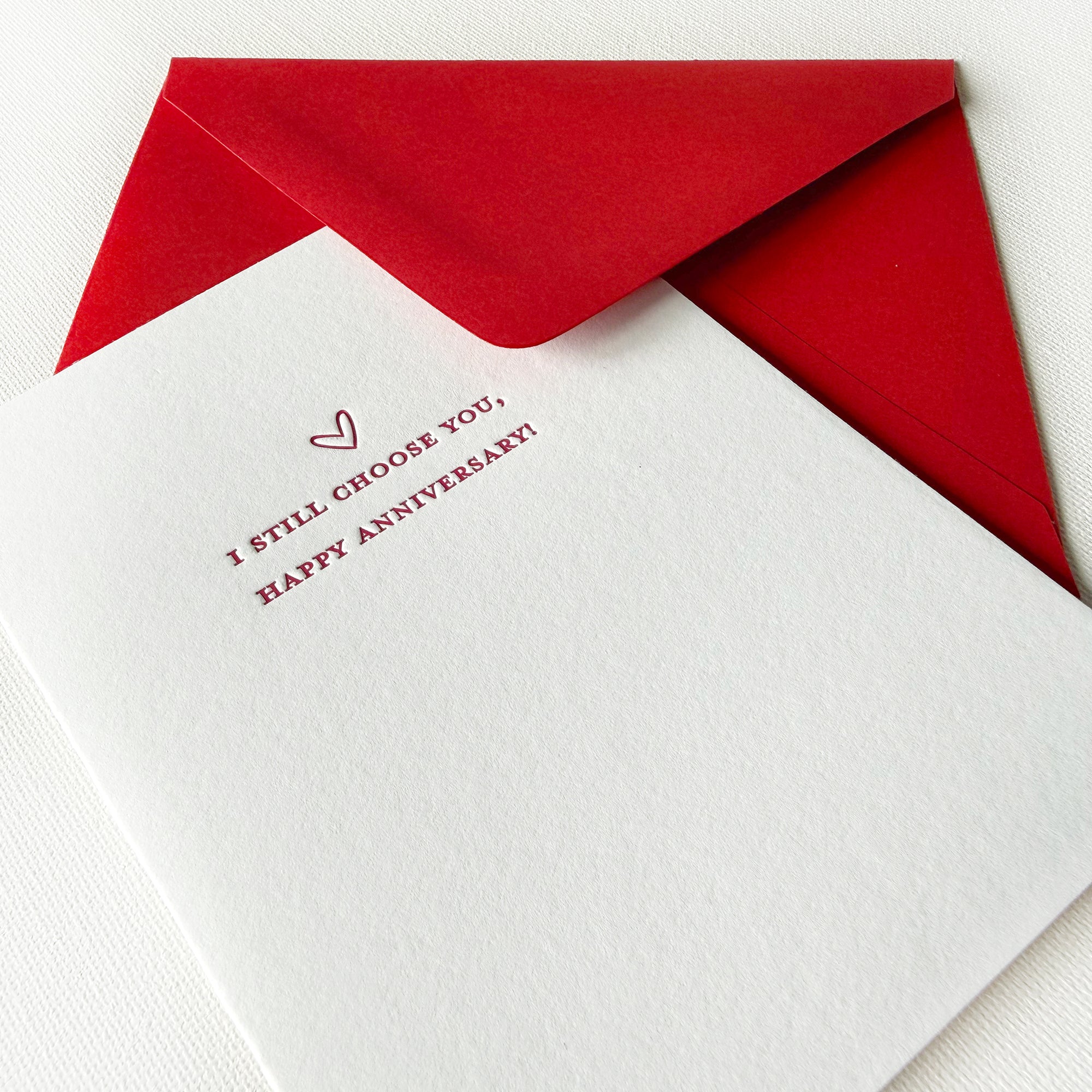 white card with 'I Still Choose You, Happy Anniversary!' text and red envelope, letterpress printed on thick white cotton stock

anniversary letterpress card with a heart